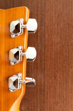 Ahşap bir arka planda akustik gitar yakası. Pin mekanizması. Arkaplan ve dokular