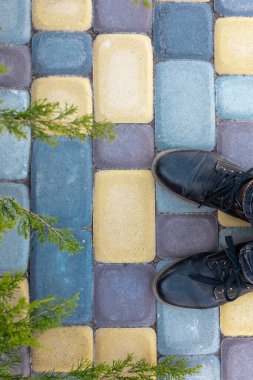 Siyah deri ayakkabılar ardışık renkli kaldırım taşları.