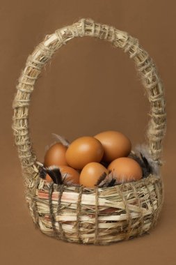 Kahverengi arka planda sepette taze tavuk yumurtası.