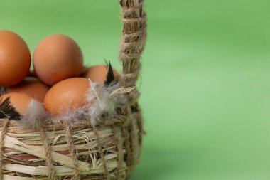Yeşil arka planda sepette tavuk yumurtası. Hasır sepet.