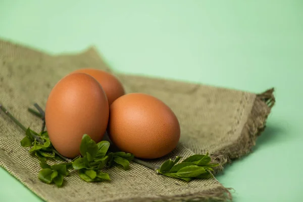 Коричневые Яйца Лежат Мешковине Зеленом Фоне — стоковое фото
