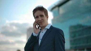 Gülümseyen bir iş adamı cep telefonuyla konuşuyor. Keyifli iş gezici sohbet