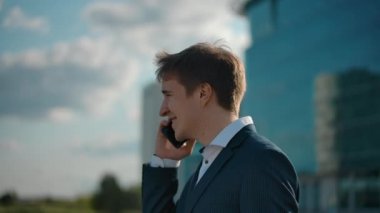 Neşeli iş adamı cep telefonuyla gülümsüyor. Uçak kalkış arkaplanı. 