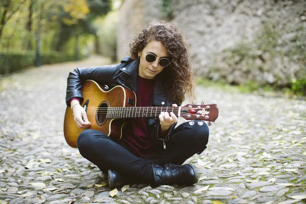 Piękna młoda kobieta gra na gitarze w lesie. — Zdjęcie stockowe