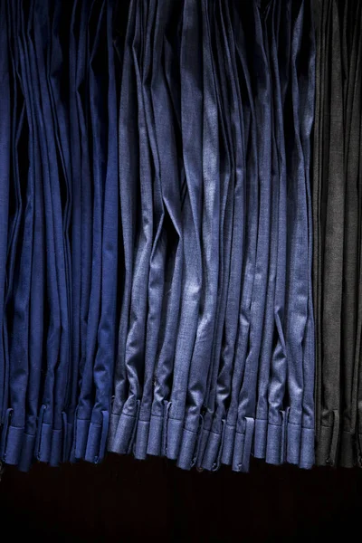 Calças masculinas penduradas em um cabide dentro de uma loja de roupas . — Fotografia de Stock