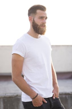 Sakallı adam sokakta poz.