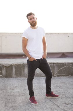 Sakallı adam sokakta poz.