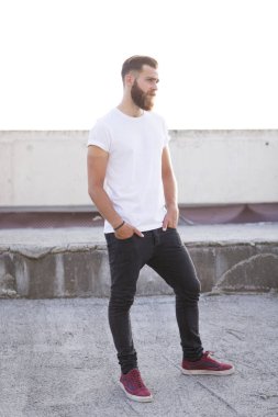 Sakallı adam sokakta poz.