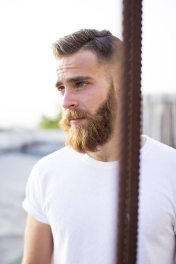 Sakallı adam sokakta poz.