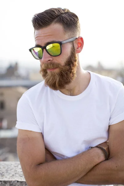 Hombre barbudo posando en la calle con gafas de sol . — Foto de Stock