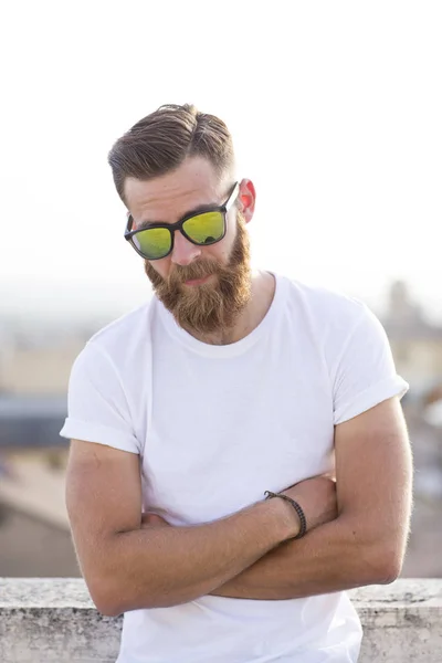 Bearded man posing in the street with sunglasses. — Stock Photo, Image