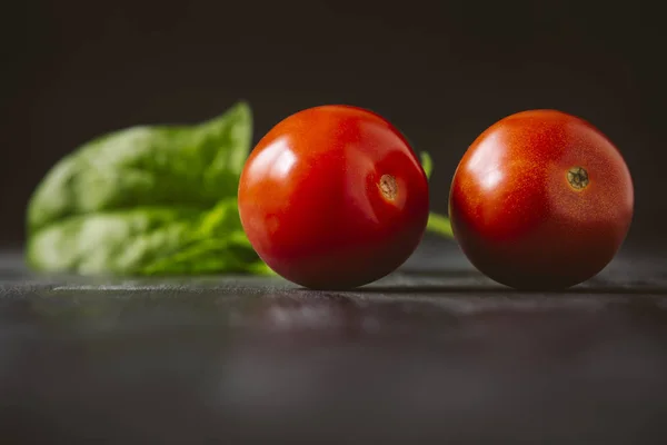 Tomatoes on a black wooden background.