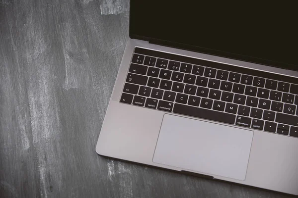 Image of a new laptop seen from above on a wooden background.