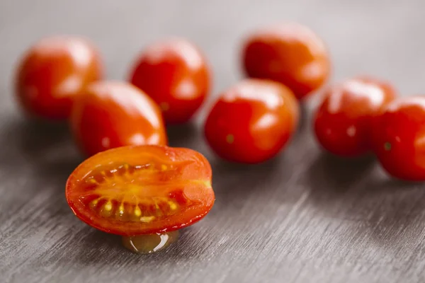 Tomates cherry sobre fondo negro de madera . Imágenes de stock libres de derechos