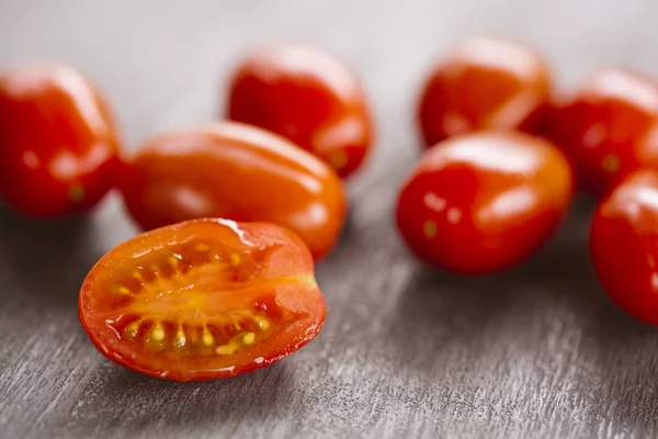 Tomates cherry sobre fondo negro de madera . Imágenes de stock libres de derechos