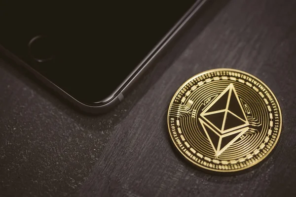 Hareket eden telefon yanında altın sikke ethereum. — Stok fotoğraf