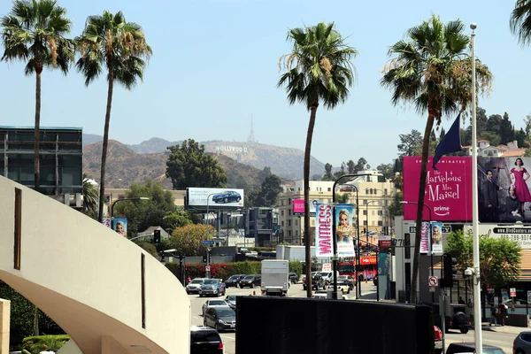 Los Angeles 'ta Hollywood tabelasının olduğu bölge. Güzel Hollywood otoyolu. Araba palmiyeleri ve tepelerinde bir tabela var. — Stok fotoğraf