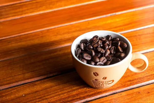 테이블에 컵에 커피 콩 — 스톡 사진