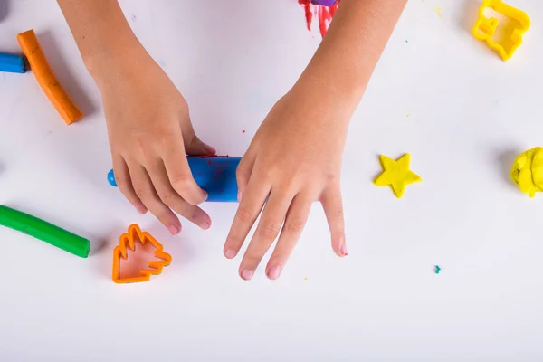 Pequeña mano de niño aprender a jugar masa coloful en la mesa blanca —  Fotos de Stock