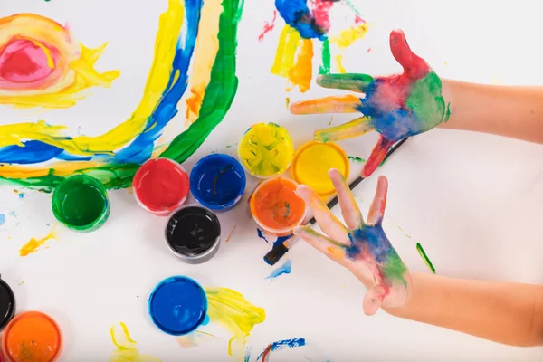 Маленька рука дитини навчиться грати барвистий колір на білому папері — стокове фото
