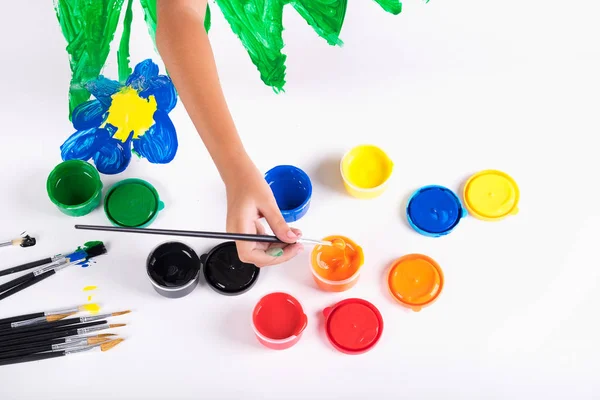 Kleine Hand des Kindes lernen, bunte Farbe auf weißem Papier zu spielen — Stockfoto