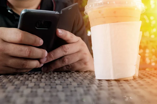 Primo Piano Uomo Che Utilizza Smartphone Cellulare Con Caffè Freddo — Foto Stock