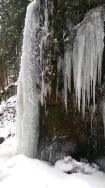 Buz saçakları olan donmuş bir dere.