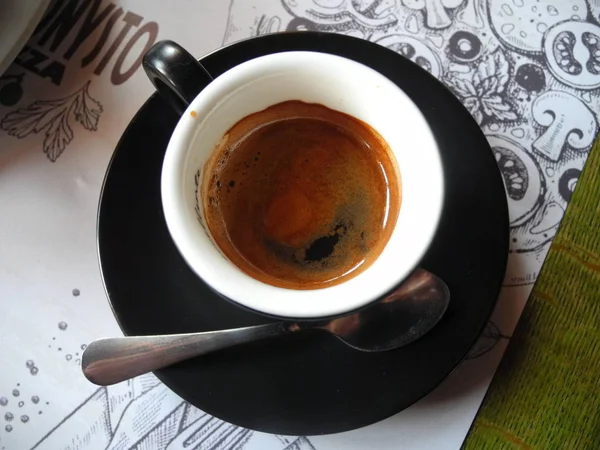一杯浓缩咖啡中的咖啡 放在勺子旁边的盘子里 — 图库照片