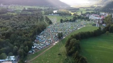 Yeşil ve yemyeşil dağlık bir bölgedeki bir müzik festivalinde kamp alanının insansız hava aracı görüntüsü..