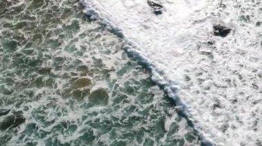 Portekiz, Algarve 'de bir plajda uçan beyaz su dalgalarının insansız hava aracı görüntüsü..
