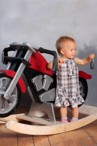 小さなバイカー女の子遊びとともに赤いおもちゃの自転車 — ストック写真