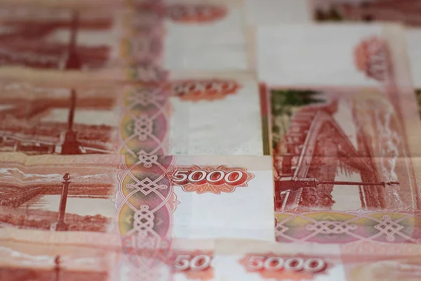 banknotes is a solid background. Banknotes five thousand Russian rubles. Focus on 5000 figure. The color of the banknotes is red and white. Close up photo