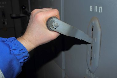 engineering systems, the hand of the worker turns off the switch. close up photo in gray color