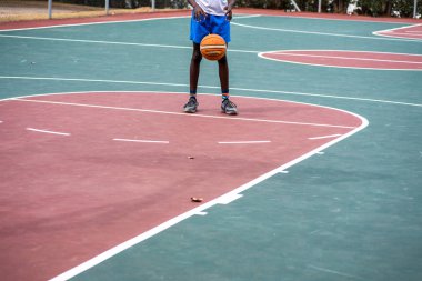 Genç çocuk serbest atışlarını sahada yapıyor.