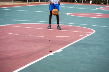 Genç çocuk serbest atışlarını sahada yapıyor.