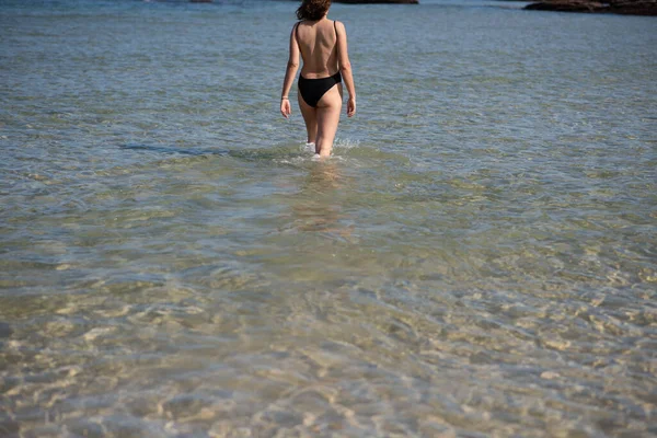 Jeune femme se dirigeant vers l'eau pour une baignade — Photo