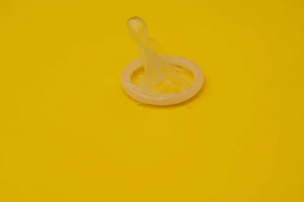 Condom isolated against yellow background — Stock Photo, Image