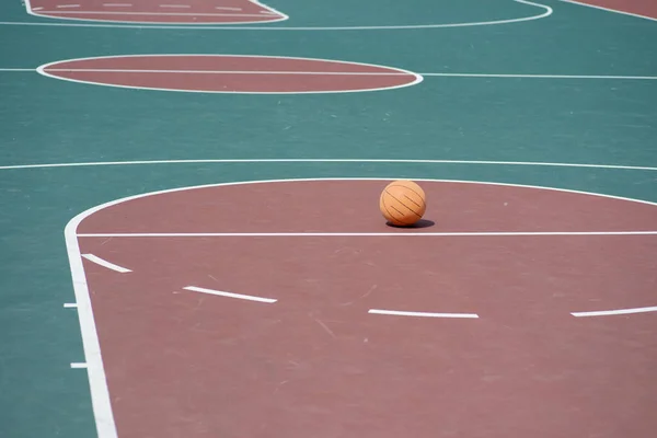 Баскетбол на пустой баскетбольной площадке вдоль линии свободного броска — стоковое фото