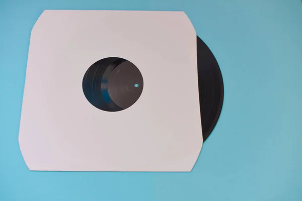 Vinyl record in sleeve isolated against blue background — Stock Photo, Image