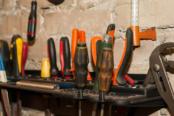 Ferramenta de trabalho do assistente. Chaves de fenda, alicates, cortadores de fios, nível de construção e outras ferramentas em uma superfície de madeira . — Fotografia de Stock