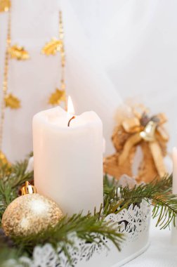 Noel ya da yeni yıl kartı. Arka planda yanan beyaz mumlar. Altın toplar ve hediyeli kutular.