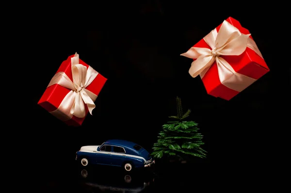 Modelo de carro Em um fundo preto com uma pequena árvore de Natal. e presentes voadores. Para descontos, seguro — Fotografia de Stock
