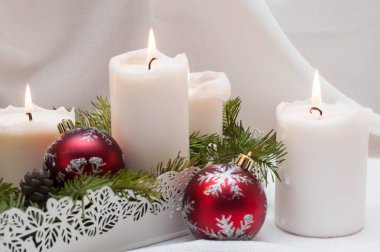 Noel ya da yeni yıl kartı. Arka planda yanan beyaz mumlar. Hediyeli kırmızı toplar. Köknar dallarında dur
