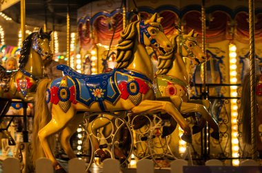 Akşamları ve akşamları lunaparktaki çocuk atlıkarıncasında. Geceleyin eğlence parkı. Şehirdeki açık hava klasik renkli atlıkarınca.