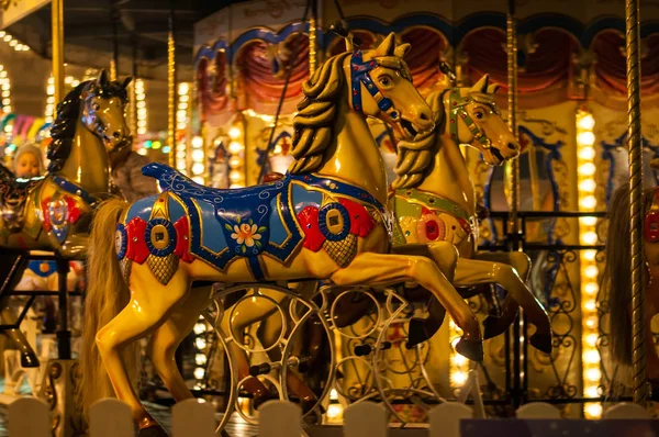 Children\'s Carousel at an amusement park in the evening and night illumination. amusement park at night. Outdoor vintage colorful carousel in the the city