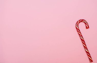 Noel kompozisyonu. Pembe arka planda Noel karameli. Düz konum, üst görünüm, kopyalama alanı