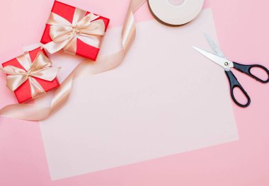 Noel kompozisyonu. Noel hediyesi, karamel, kozalak, pembe arka planda. Düz konum, üst görünüm, kopyalama alanı