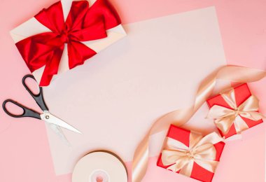 Noel kompozisyonu. Noel hediyesi, karamel, kozalak, pembe arka planda. Düz konum, üst görünüm, kopyalama alanı