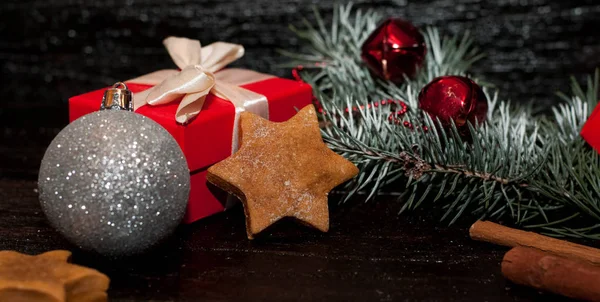 Natal fundo escuro com decoração festiva, biscoitos, pão de gengibre e ramos de abeto — Fotografia de Stock