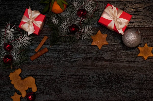 Fond sombre de Noël avec décoration festive, biscuits, pain d'épice et branches d'épinette vue de dessus, espace pour le texte — Photo